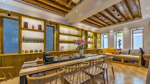 A wooden interior with a long dining table, chairs, and shelves displaying various items. - Easy Inn (Lijiang)