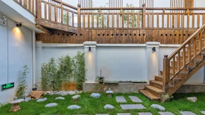 A garden with stone pathways, bamboo plants, and a wooden staircase. - Easy Inn (Lijiang)