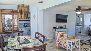 A dining area with a glass-top table, wooden chairs, and a chandelier. -  AWESOME Location with a Canal view (Port Richey)
