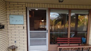 A building entrance with a glass door, a bench, a welcome mat, and a sign on the wall. -  AWESOME Location with a Canal view (Port Richey)