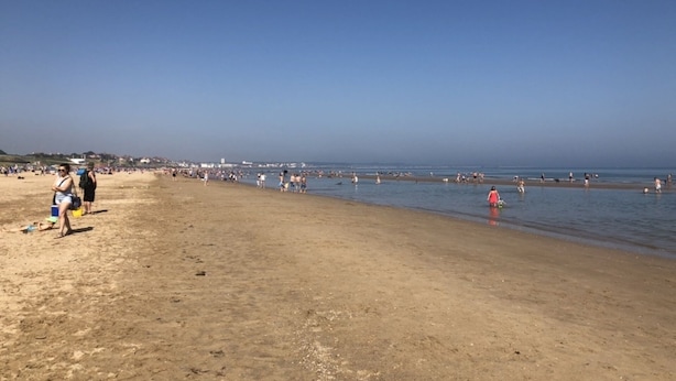 A wide sandy beach with people walking and swimming. - Captivating 2-bed Chalet (Bridlington)
