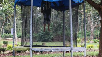 Un trampolín con un dosel azul en un área boscosa.