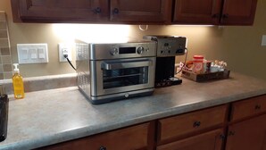 A kitchen with a stainless steel oven, a coffee maker, and a bottle of dish soap on the counter. - Spacious Two-Bedroom Suite in Salt Lake Valley (West Jordan)