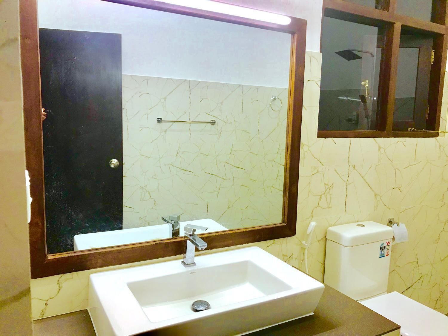 A bathroom with a white sink, a mirror, and a toilet.