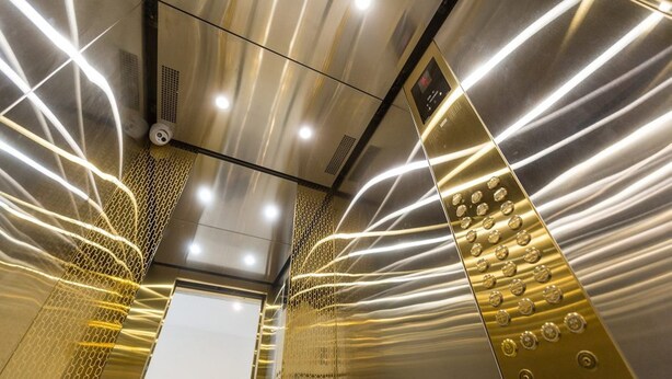 An interior view of an elevator with metallic walls and a reflective surface. - Apartment Yuri 42-76 (Odesa)