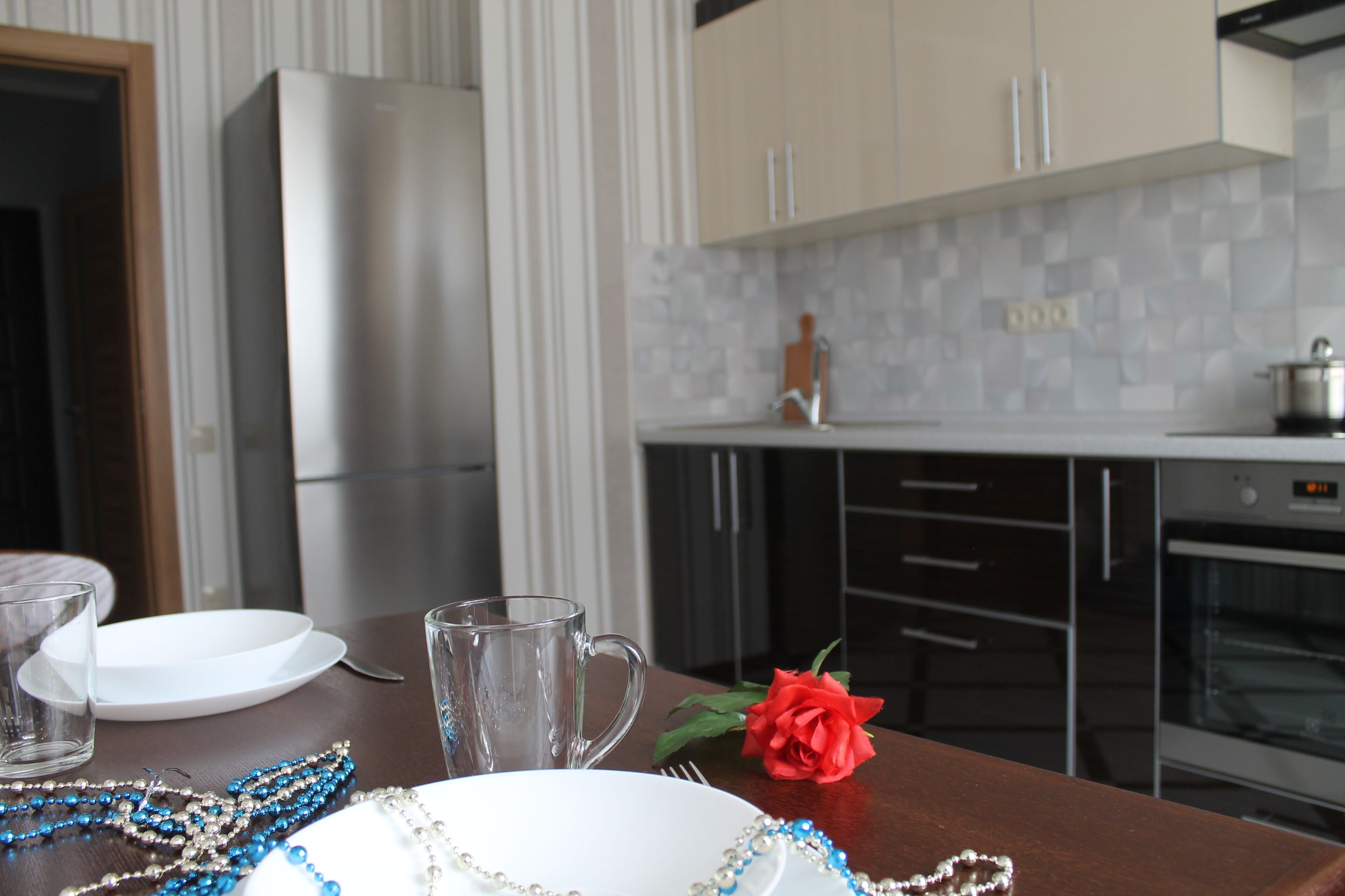 Una cocina con refrigerador, horno y salpicadero de azulejos.