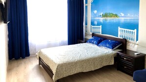 A bedroom with a bed, a nightstand, a dresser, and a large window with curtains. - Apartment Yuri 42-76 (Odesa)