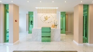 A modern reception area with a marble reception desk, a decorative wall with a golden fox and stars, and a green accent wall. - Apartment Yuri 42-76 (Odesa)