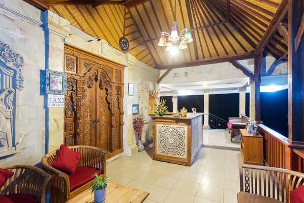 A lobby with wooden furniture, a reception desk, and a clock on the wall.