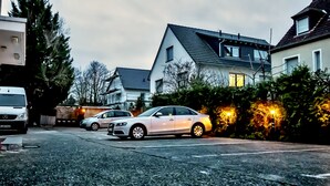 Een woonstraat met geparkeerde auto's en huizen.