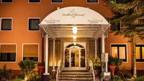 Een hotelentree met een overdekte veranda, trappen die naar de deur leiden en een bord met restaurant en lounge/bar.