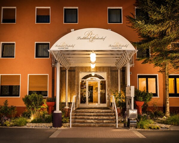 A hotel entrance with a covered porch, steps leading up to the door, and a sign indicating a restaurant and lounge/bar. - Parkhotel Lindenhof (Offenbach am Main)