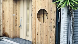 A wooden door with a circular window and a small step leading to the entrance. - Osaka Premium House (Osaka)