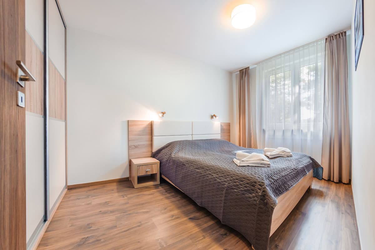 Ein Schlafzimmer mit Bett, Nachttisch und Beistelltisch.