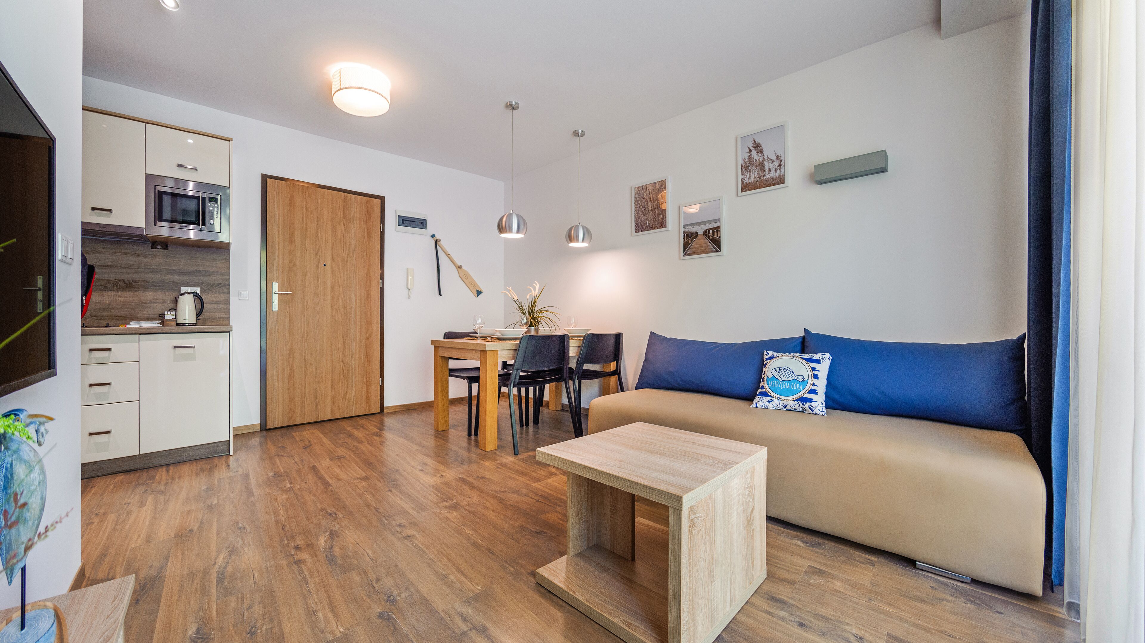 Una sala de estar moderna con un sofá, una mesa de comedor y una zona de cocina.