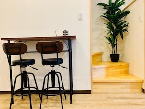 Un comedor con dos taburetes negros y una mesa de madera.