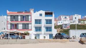 A multi-story building with balconies and a beachside location.