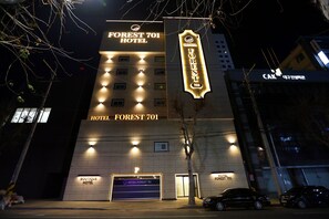 A hotel with a prominent sign reading "FOREST 701 HOTEL" and a parking area labeled "P".