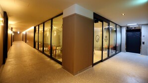 A modern hotel corridor with glass doors, a reception area, and a cafe sign. - Forest 701 Hotel (Daegu)