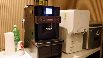 Una máquina de café y un dispensador de agua sobre una encimera.