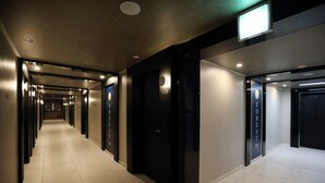 A hotel corridor with multiple doors, each labeled with room numbers. - Forest 701 Hotel (Daegu)