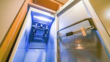 A compact, modern refrigerator with a transparent door, allowing visibility of its contents.