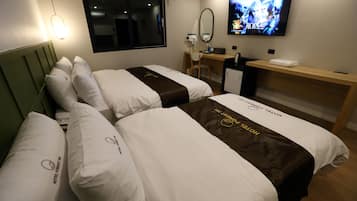 Una camera d'albergo con due letti, una scrivania, una televisione e uno specchio.