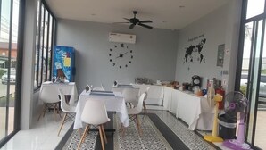 A modern dining area with a clock, a map, and a ceiling fan. - The Phu Resort (Pranburi)
