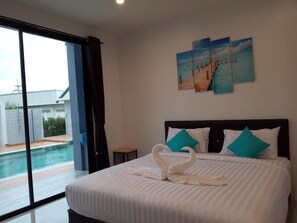 Une chambre avec un lit, une vue sur une piscine et un tableau accroché au mur.