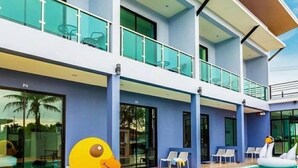 A modern hotel with a swimming pool, a duck float, and lounge chairs. - The Phu Resort (Pranburi)