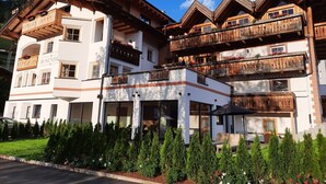 Un hotel de varios pisos con balcones, un letrero que dice 'ROSENHOLZ' y un jardín bien cuidado.
