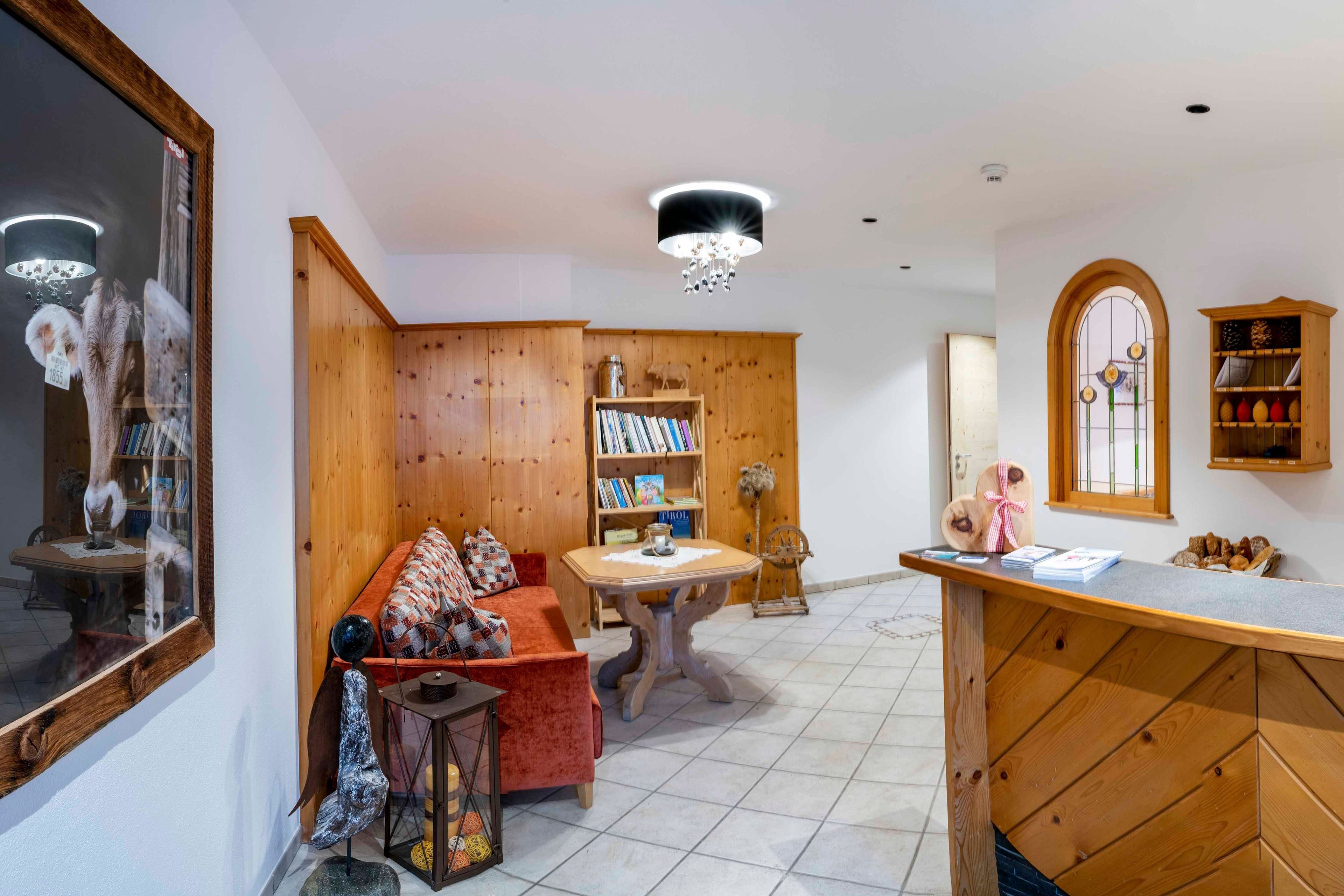 Una zona de estar acogedora con un sofá, estanterías de madera, una mesa y un espejo decorativo.