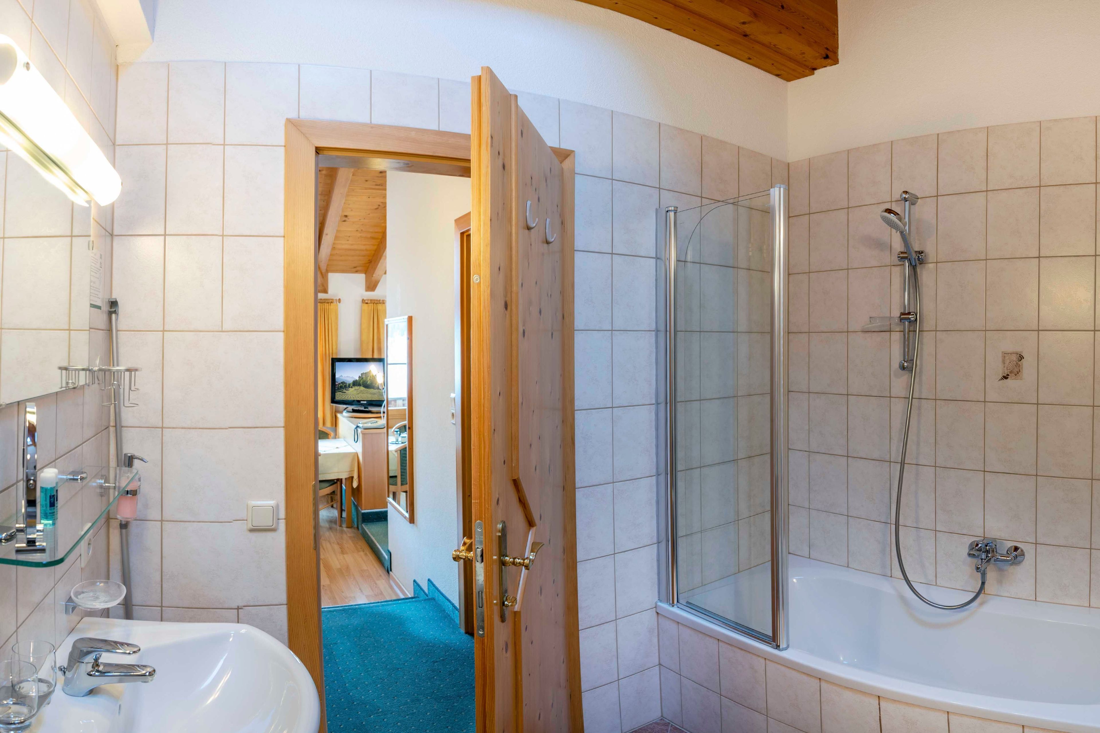 Ein Badezimmer mit Dusche, Waschbecken und Spiegel.