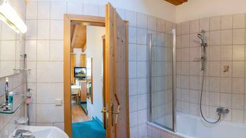 Ein Badezimmer mit Dusche, Waschbecken und Spiegel.