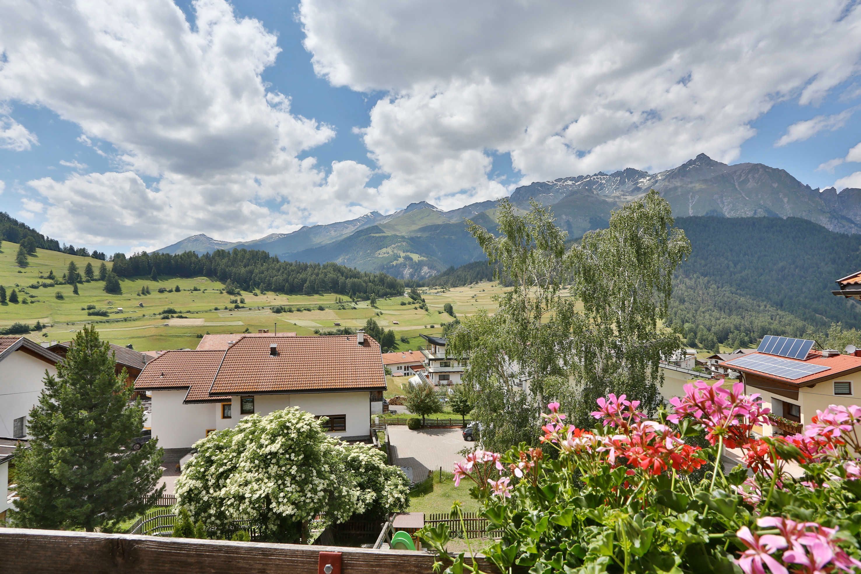 A residential area with houses, a mountain range, and a clear sky.