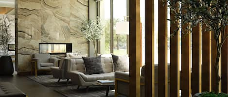 A modern living room with a marble wall, a sofa set, a coffee table, and a potted plant.