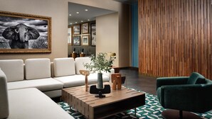 A modern living room with a sofa, a coffee table, and a green armchair. - Hyatt House LAX/Century Blvd (Los Angeles)