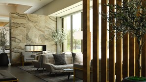 A modern living room with a marble wall, a sofa set, a coffee table, and a potted plant. - Hyatt House LAX/Century Blvd (Los Angeles)