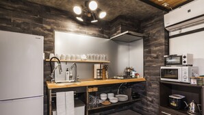 Una cucina moderna con un piano di lavoro in legno, elettrodomestici integrati e una lampada a sospensione.
