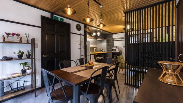Zona pranzo con tavolo in legno, sedie e lampadari a sospensione.