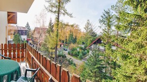 A balcony with a view of a residential area, including houses and trees. - Apartamenty Sun & Snow Moniuszki (Karpacz)