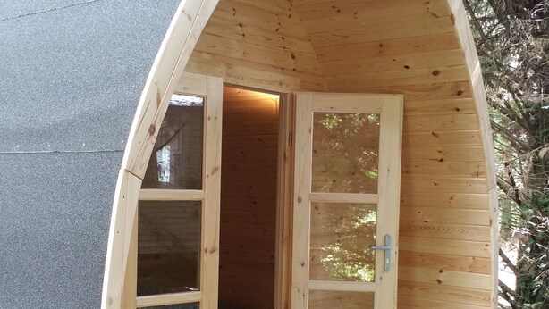A wooden cabin with a sloped roof, two large windows, and a door. - Au Tour De L'Aveyron (L'Hospitalet-du-Larzac)