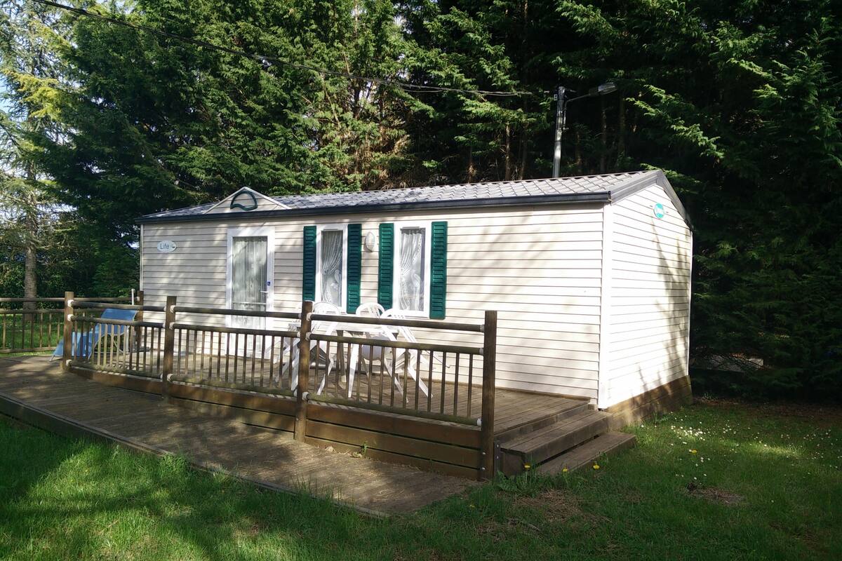 Een klein, gelijkvloers vakantiehuis met een omheind terras en een overdekte zithoek buiten.