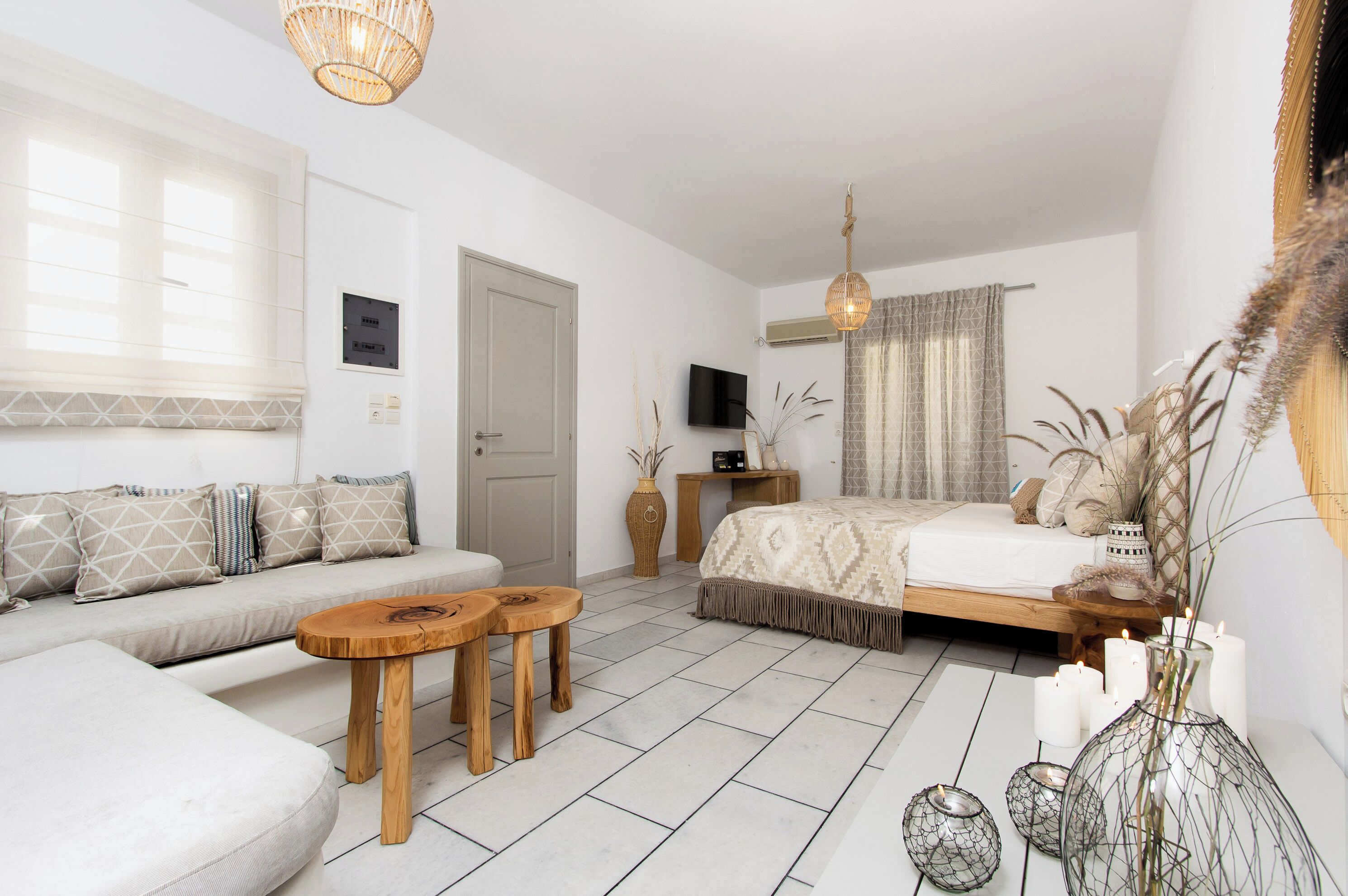 Et moderne soveværelse med sofa, seng, fjernsyn og sofabord i træ.