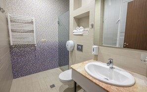 Habitación estándar con 1 cama matrimonial o 2 individuales | Baño | Regadera, amenidades de baño gratuitas, secadora de cabello, batas 