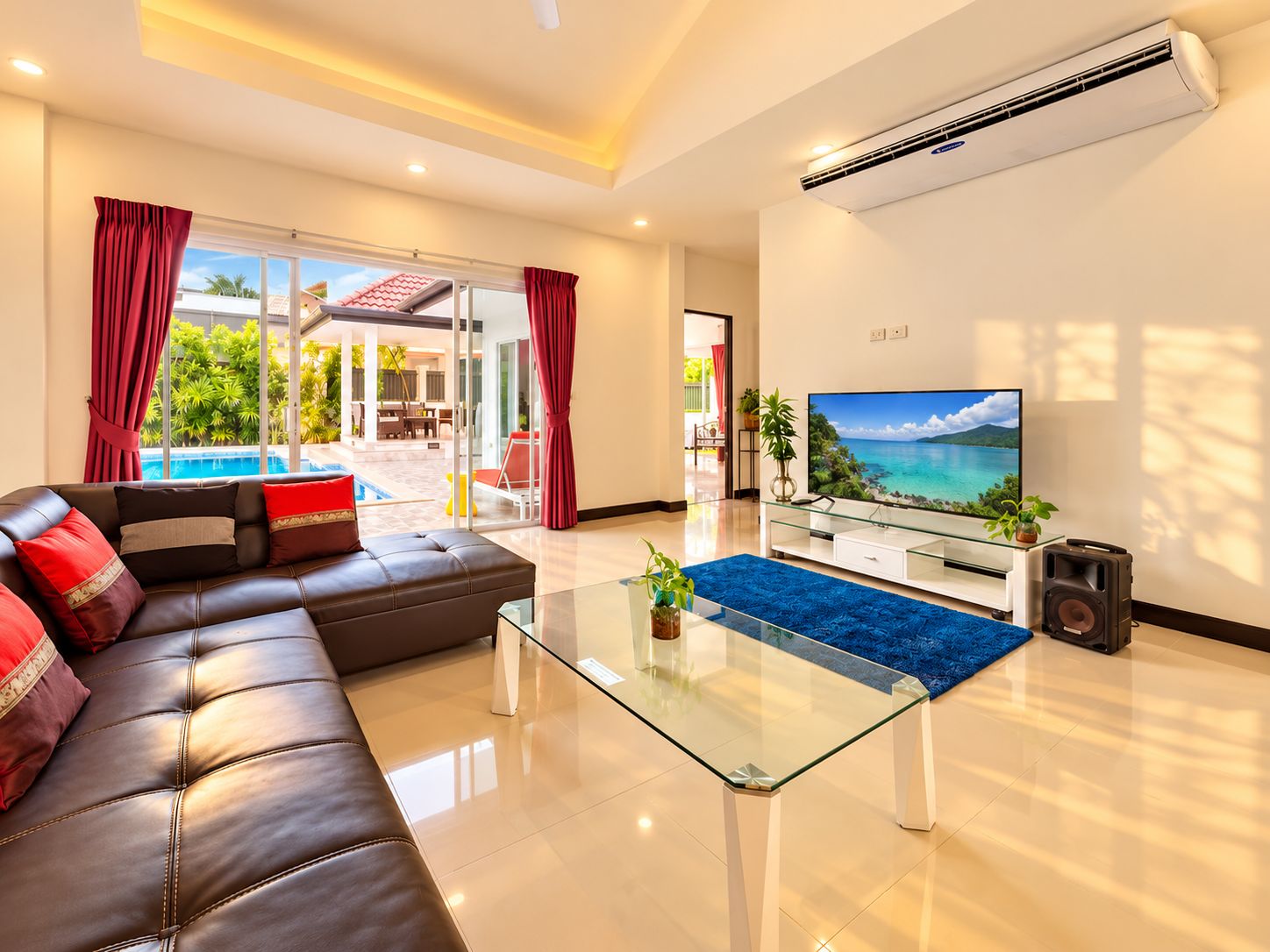 Una sala moderna con un sofá de cuero, una mesa de centro de vidrio y un televisor de pantalla plana.