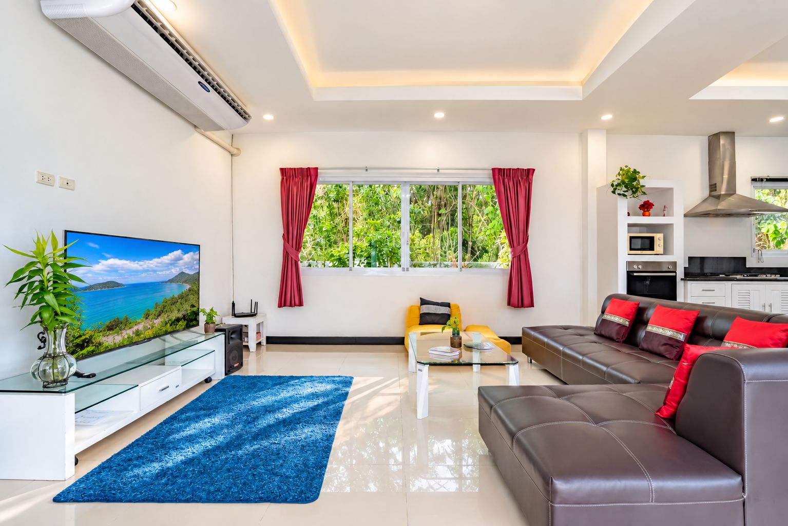Una sala de estar moderna con un sofá, una mesa de centro, un televisor y una zona de cocina.