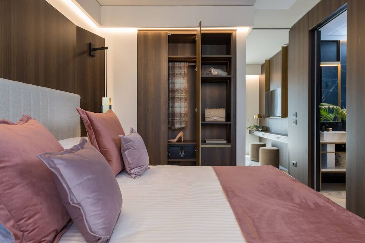 Un dormitorio moderno con una cama grande, un armario y un tocador.