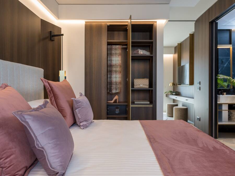 Un dormitorio moderno con una cama grande, un armario y un tocador.
