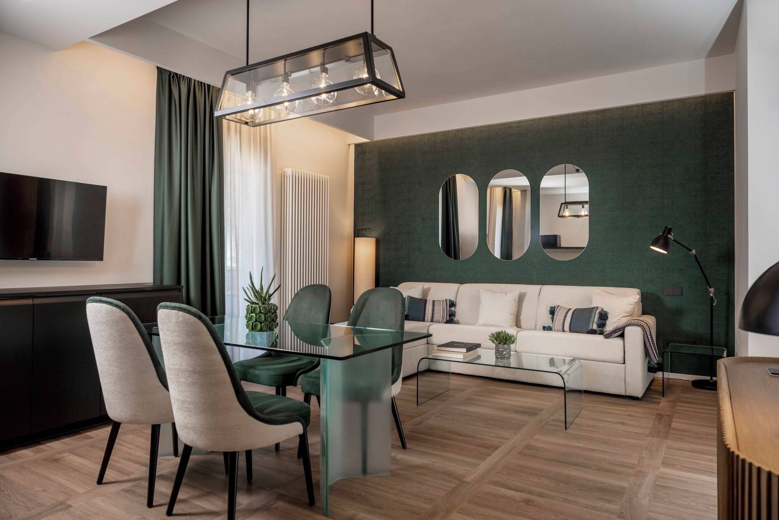 Uma sala de estar moderna com uma mesa de centro de vidro, um sofá e uma área de jantar com cadeiras.